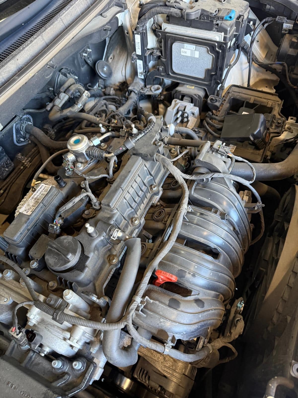 A car engine bay opened up at the North Albury workshop, with the intake manifold and engine control unit exposed for diagnostic testing